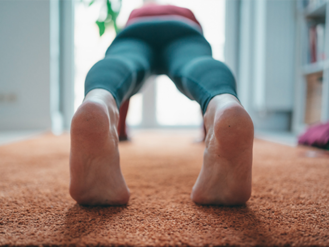 A person performs a press up on a mat at home