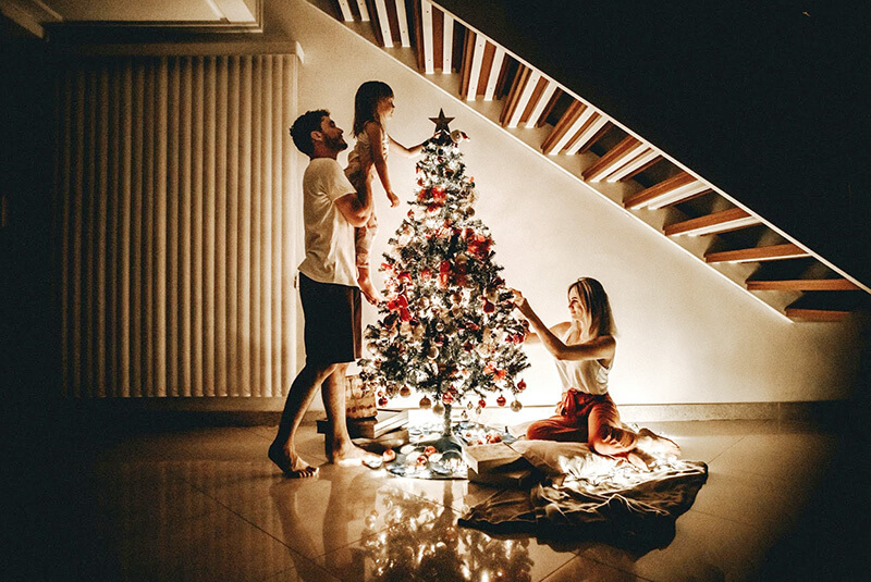 A family decorate a Christmas tree together